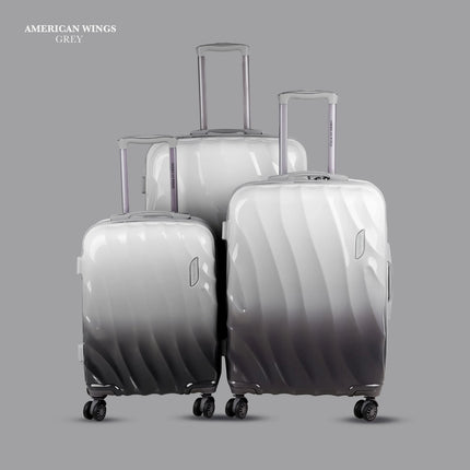 Set of three grey hard-shell suitcases with wheels and telescopic handles on a grey background